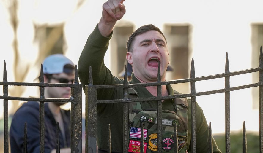 Jake Lang shouts from a sidewalk as New York Mayor Zohran Mamdani speaks during a news conference at Gracie Mansion, Monday, March 9, 2026, in New York. (AP Photo/Angelina Katsanis)