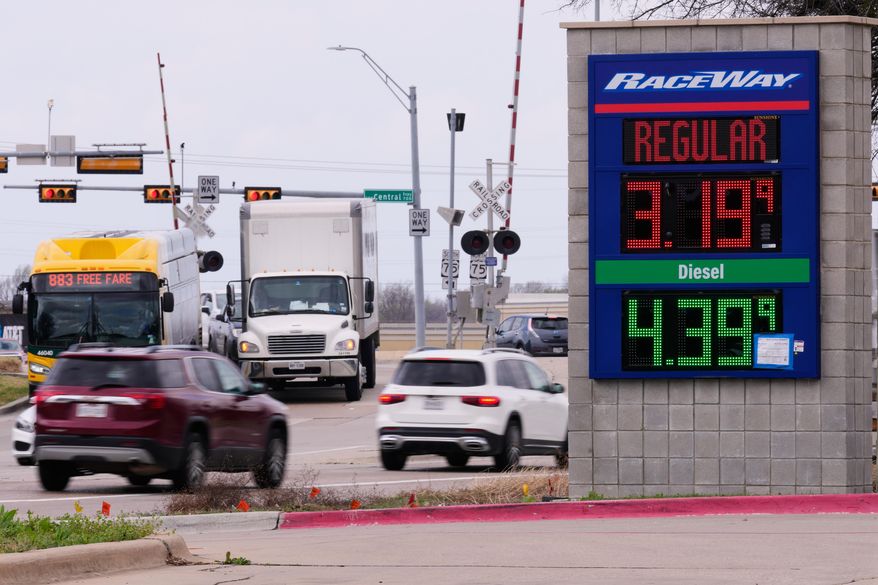 Drivers navigate a busy intersection past a sign displaying the current gas prices at a filling station in Plano, Texas, March 6, 2026. (AP Photo/Tony Gutierrez, File)