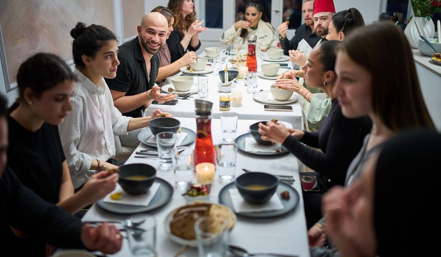 Gay Muslim influencer Ali Darwich, center left, hosts an inclusive Iftar, the Ramadan fast-breaking meal, with friends who are Muslim, Christian, queer and straight, in Berlin, Germany, Wednesday, March 11, 2026. (AP Photo/Ebrahim Noroozi)