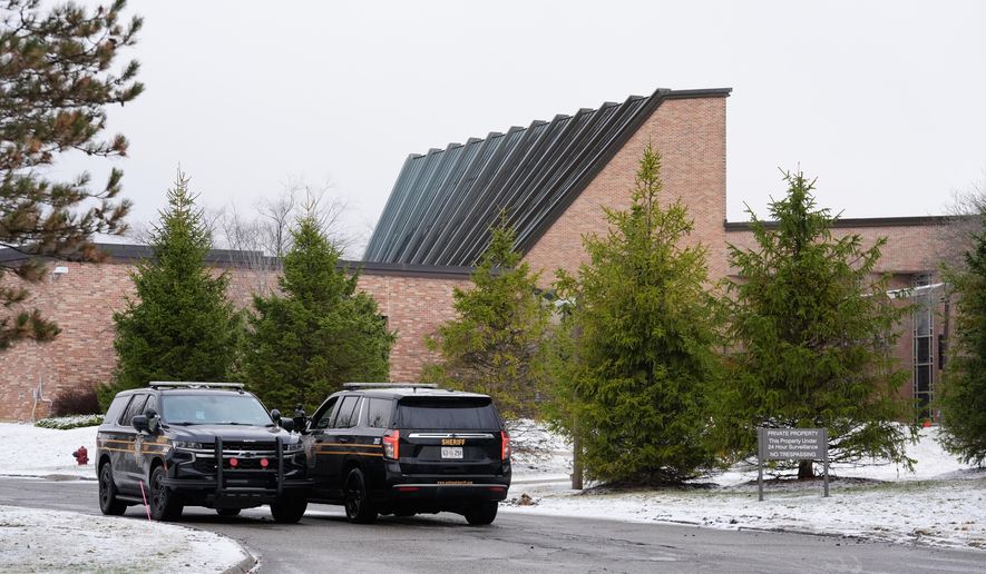 Police vehicles sit outside the Temple Israel synagogue Friday, March 13, 2026, in West Bloomfield Township, Mich. (AP Photo/Paul Sancya)