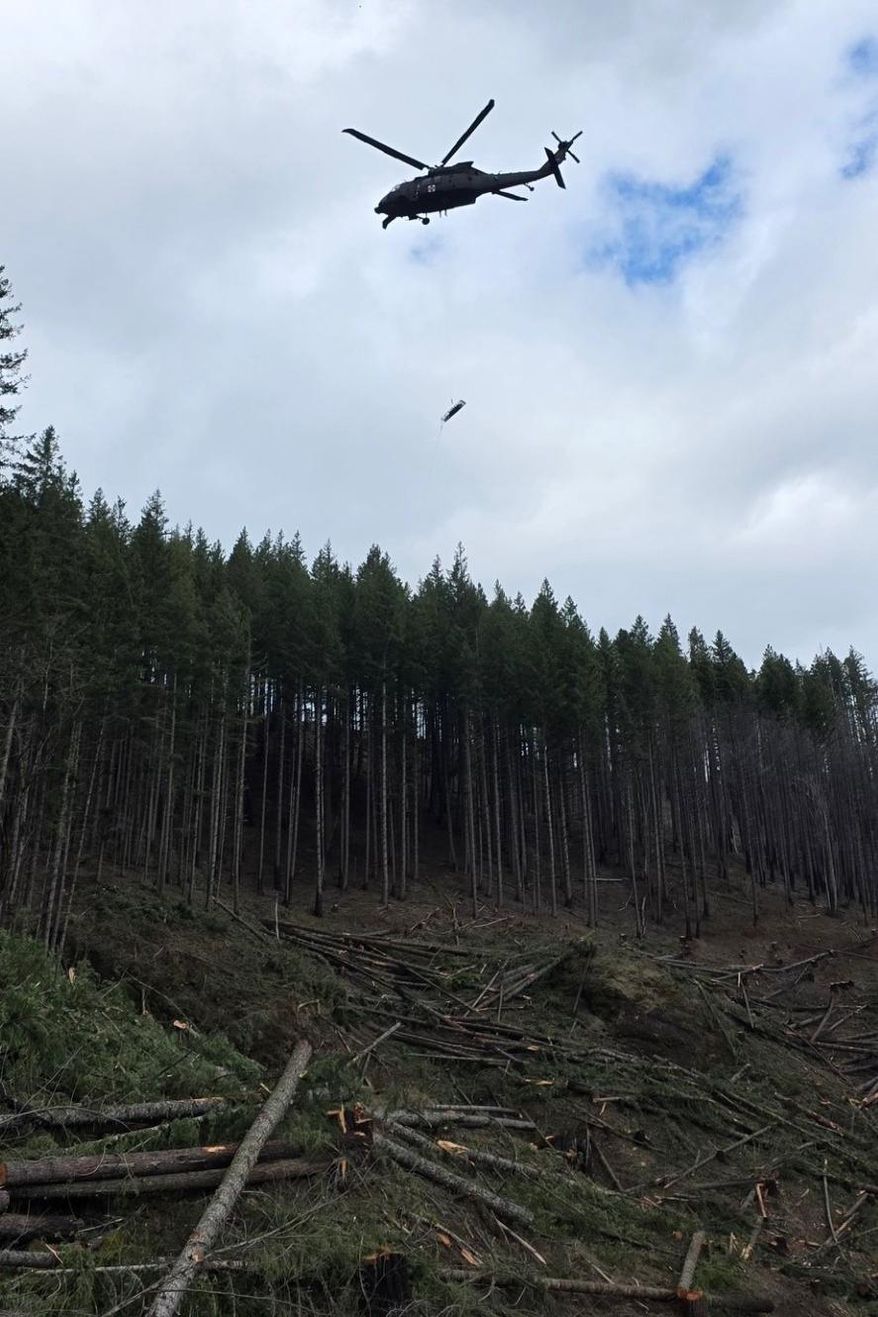 In this handout photo provided by the Estacada Fire District, an Oregon Army National Guard helicopter rescues an injured logger from Mount Hood National Forest, Thursday, March 12, 2026, after rough terrain prevented other means of rescue. (Estacada Fire District via AP)