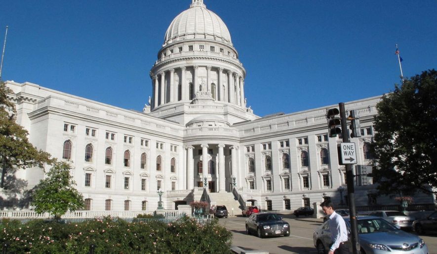 A man walks by the Wisconsin state Capitol in Madison, Wis., on Oct. 10, 2012. (AP Photo/Scott Bauer, File)