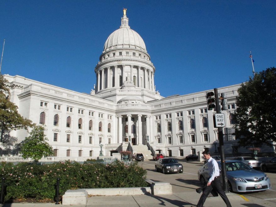 A man walks by the Wisconsin state Capitol in Madison, Wis., on Oct. 10, 2012. (AP Photo/Scott Bauer, File)