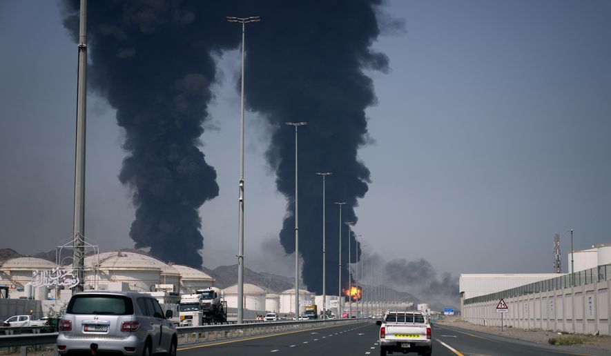 A fire and plumes of smoke rise after debris from an intercepted Iranian drone struck an oil facility, according to authorities, in Fujairah, United Arab Emirates, Saturday, March 14, 2026. (AP Photo/Altaf Qadri)