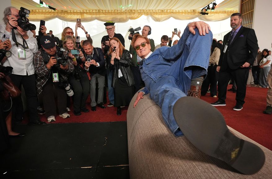 Academy Awards host Conan O'Brien poses atop a roll of red carpet during the annual Oscars red carpet roll out on Wednesday, March 11, 2026, at the Dolby Theatre in Los Angeles. (AP Photo/Chris Pizzello)