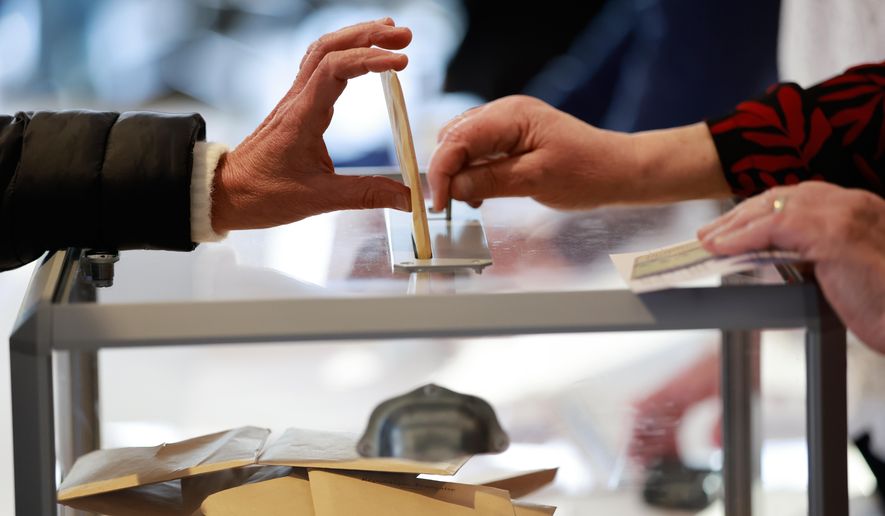 A woman castes her ballot during the first round of France's municipal elections in Henin-Beaumont, northern France, Sunday, March 15, 2026. (AP Photo/Jean-Francois Badias)