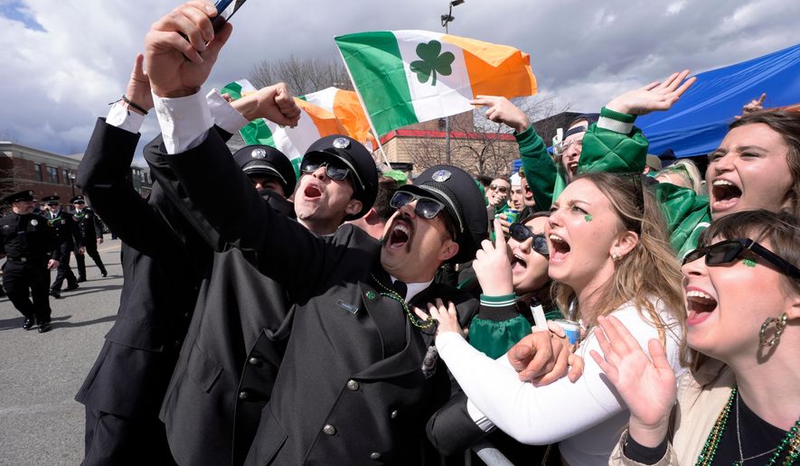 FILE - A group of firemen from around the United States pose for a selfie with spectators while marching in the St. Patrick's Day parade, March 17, 2024, in Boston's South Boston neighborhood. (AP Photo/Steven Senne, File)