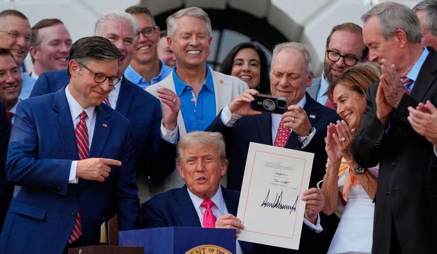 President Donald Trump holds his signed signature bill of tax breaks and spending cuts at the White House, July 4, 2025, in Washington, surrounded by members of Congress. (AP Photo/Julia Demaree Nikhinson, File)