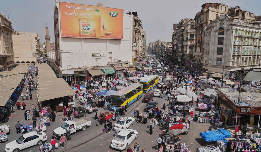 A view of people and vehicles at a popular market in Cairo, Egypt, Tuesday, March 12, 2026. (AP Photo/Amr Nabil)