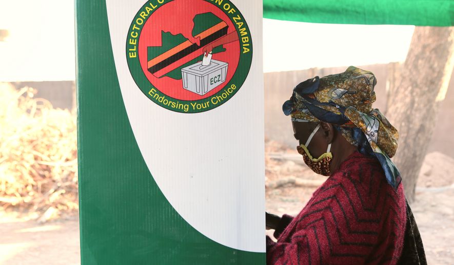 FILE - A woman is seen in a voting booth at a polling station in Lusaka, Zambia, Aug, 12, 2021. (AP Photo/Tsvangirayi Mukwazhi, File)