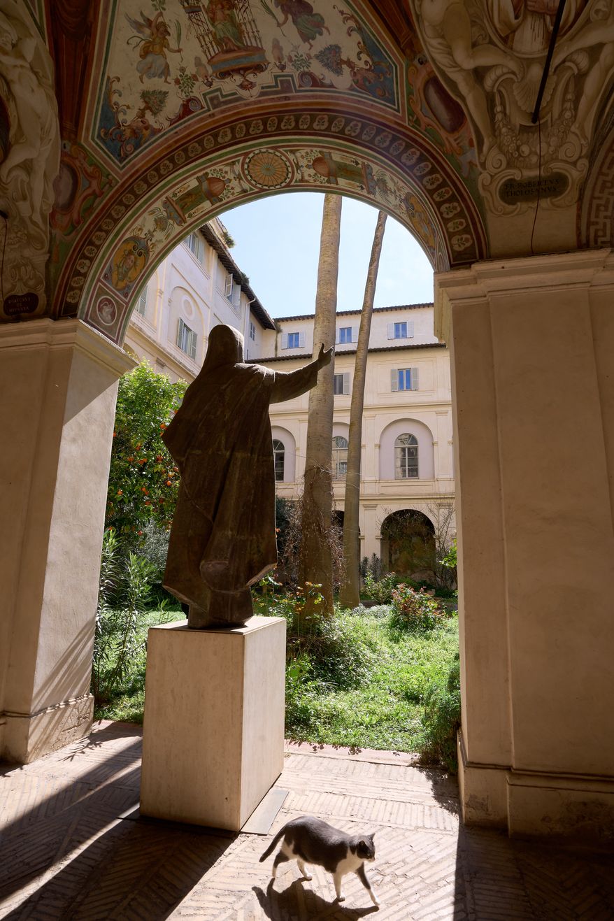 A cat sidles away as journalists visit the cloister of the Basilica of Santa Maria sopra Minerva in Rome, Wednesday, March 18, 2026. (AP Photo/Domenico Stinellis)