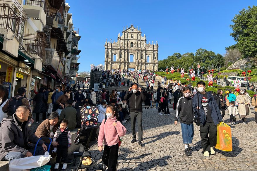 FILE - Travelers from mainland China gather near the Ruins of St. Paul's, a tourist destination in Macao, Jan. 18, 2022. (AP Photo/Kanis Leung, File)
