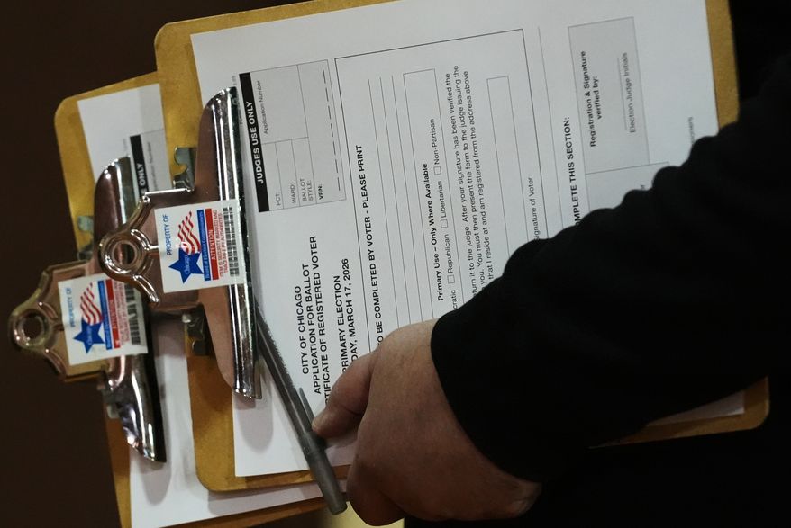 A voting official holds registration forms to vote on Election Day at Chicago Park District Loyola field house in Chicago on Tuesday, March 17, 2026. (AP Photo/Nam Y. Huh) **FILE**