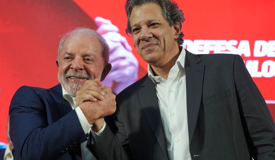 Brazilian President Luiz Inacio Lula da Silva, left, and outgoing Finance Minister Fernando Haddad shake hands during a ceremony announcing Haddad's candidacy for governor of Sao Paulo state in the October elections, in Sao Bernardo do Campo, Brazil, Thursday, March 19, 2026. (AP Photo/Andre Penner)