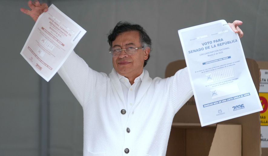 Colombia's President Gustavo Petro shows the ballots before voting in legislative elections in Bogota, Colombia, Sunday, March 8, 2026. (AP Photo/Fernando Vergara)
