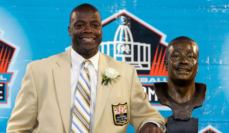 Former Washington Redskins cornerback Darrell Green stands next to his bronze bust at the Pro Football Hall of Fame in Canton, Ohio, Aug. 2, 2008. (AP Photo/Kiichiro Sato, File)
