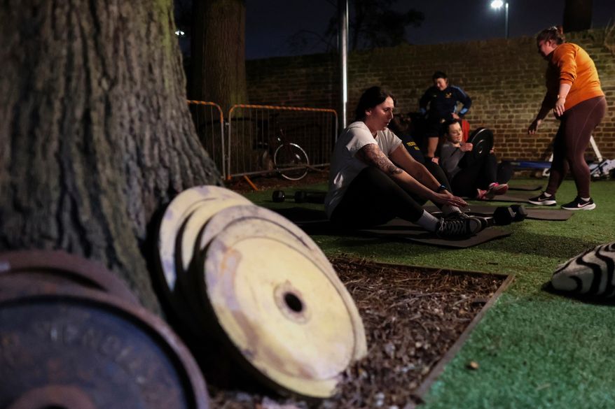 Chloe Spriggs, left, takes a moment as members of Teddington women's rugby team use weights as they train at the club house in Bushy Park in London, Thursday, Jan. 16, 2025. (AP Photo/Charlotte Coney,File)b