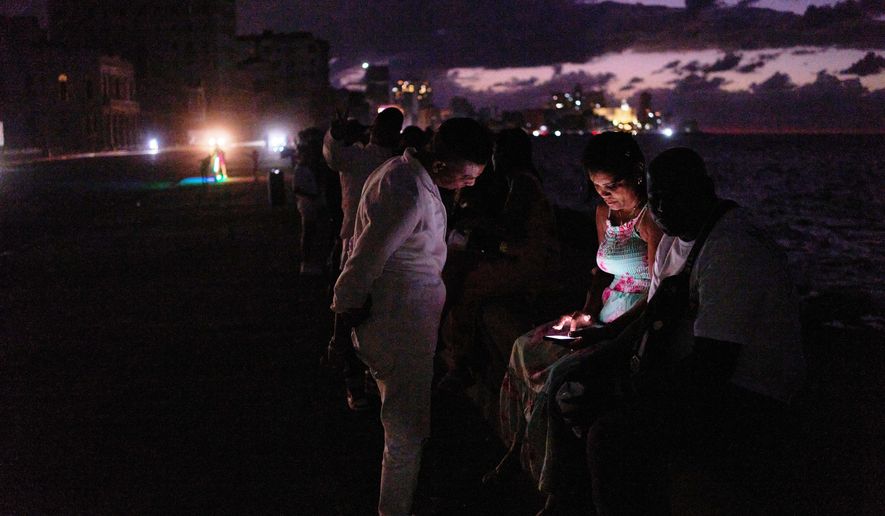 People spend the night in the dark on the Malecon during a blackout in Havana, Cuba, Saturday, March 21, 2026. (AP Photo/Ramon Espinosa)