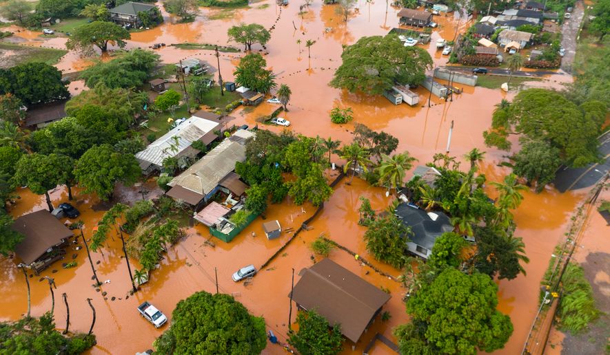 Fooding covers a residential neighborhood in Waialua, Hawaii, Friday, March 20, 2026. (AP Photo/Mengshin Lin)