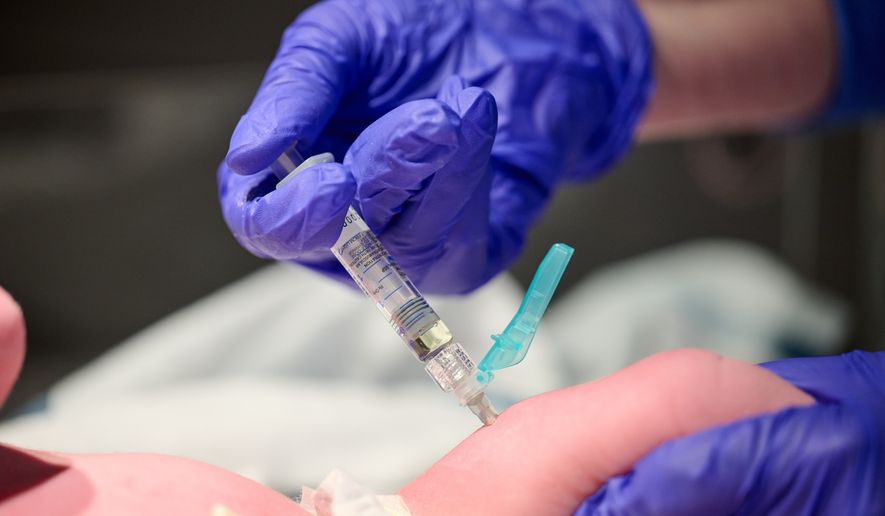 In this photo provided by Norton Healthcare, nurse Robin Waldridge administers a Vitamin K shot to a newborn baby at Norton Women's and Children's Hospital on Friday, March 6, 2026, at the hospital in Louisville, Ky. (Jamie Rhodes/Norton Healthcare via AP)