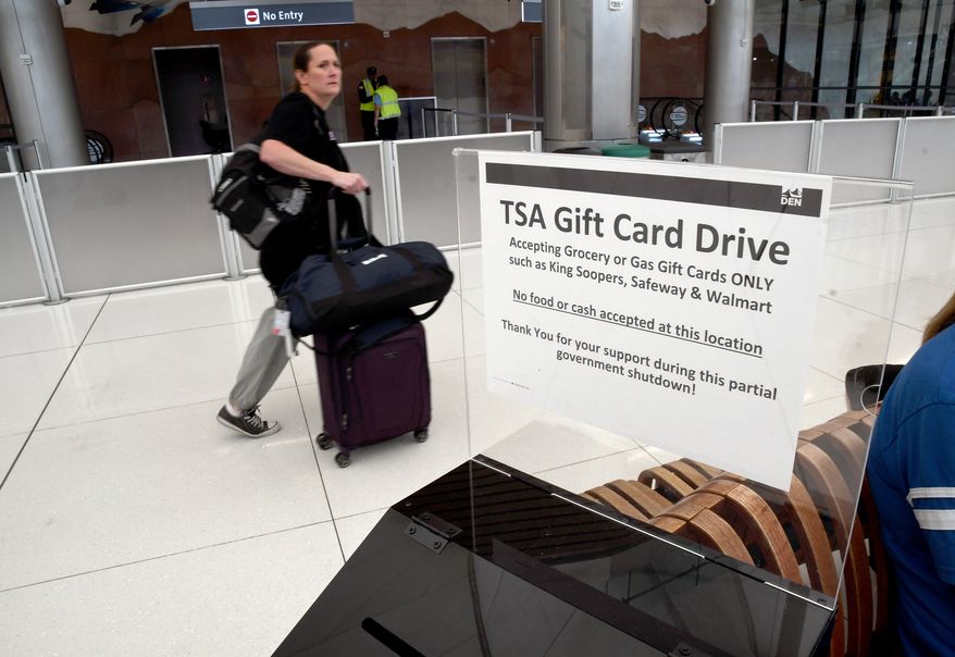 A traveler walks past a gift card donation box for Transportation Security Administration officers at Denver International Airport on Friday, March 20, 2026. (AP Photo/Thomas Peipert)