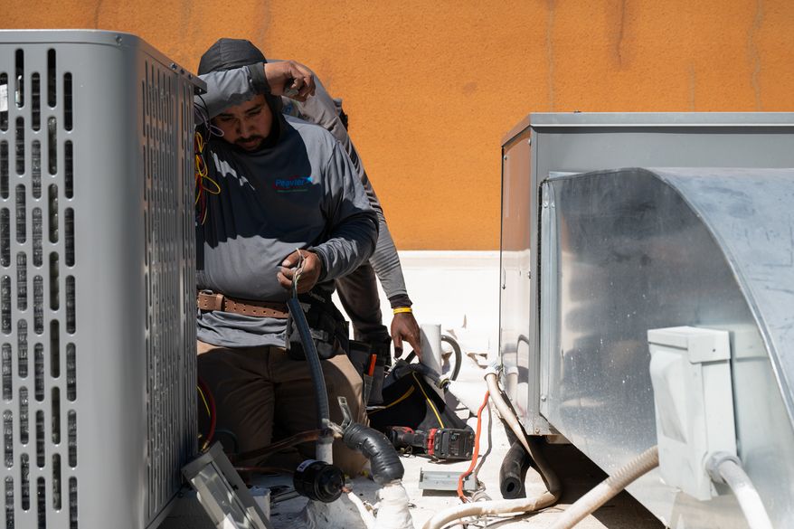 Brian Hermosillo wipes sweat from his brow while installing a new air conditioning unit during record-breaking heat Thursday, March 19, 2026, in Tempe, Ariz. (AP Photo/Caitlin O'Hara)