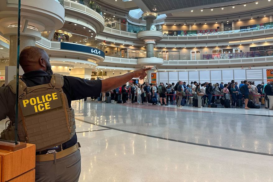 A federal immigration agent is seen as people wait in a TSA line at the Hartsfield-Jackson Atlanta International Airport, Monday, March 23, 2026, in Atlanta. (AP Photo/Emilie Megnien)