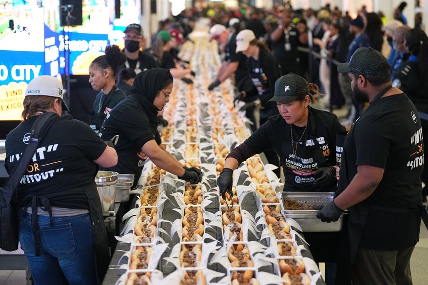 Volunteers assemble cheesesteaks in a Guinness World Record attempt on National Cheesesteak Day at Philadelphia International Airport, Tuesday, March 24, 2026, in Philadelphia. (AP Photo/Matt Rourke)