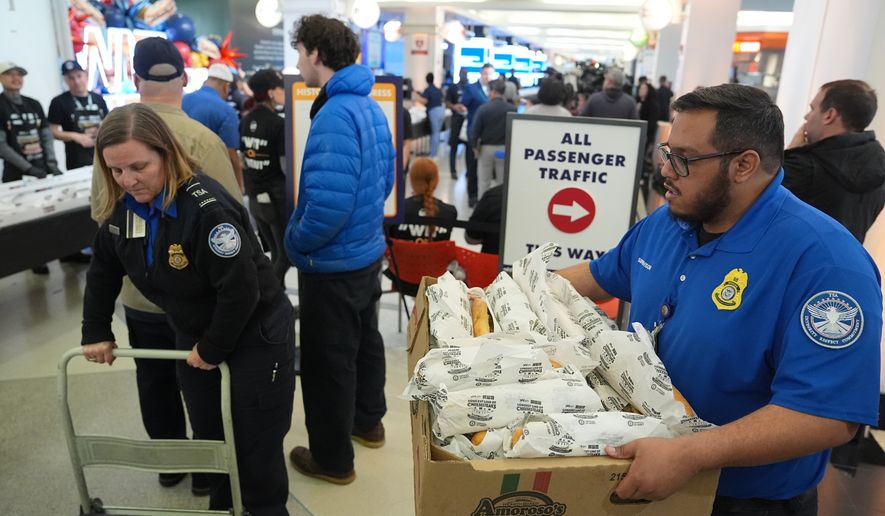Transportation Security Administration (TSA) workers collect cheesesteaks for their coworkers that were made for a Guinness World Record attempt on National Cheesesteak Day at Philadelphia International Airport, Tuesday, March 24, 2026, in Philadelphia. (AP Photo/Matt Rourke)