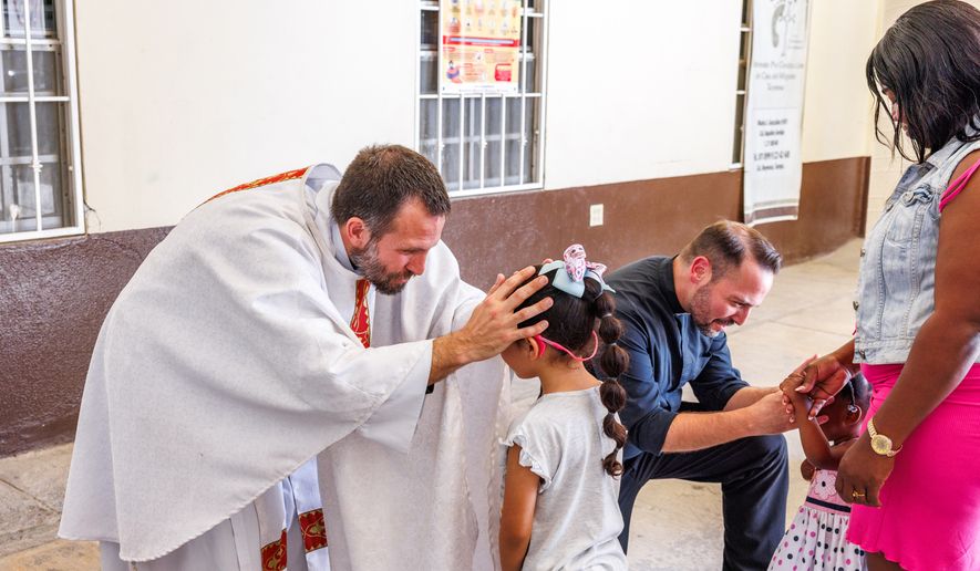 The Rev. Brian Strassburger blesses a child during Mass at Casa del Migrante on Thursday, March 19, 2026, in Reynosa, Mexico. (AP Photo/Michael Gonzalez)