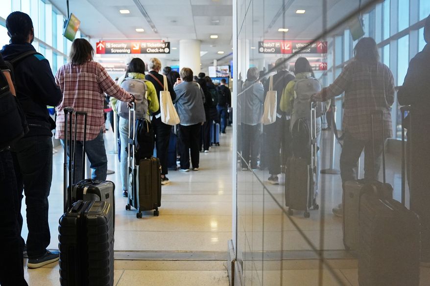 Travelers wait in a security check point line at Philadelphia International Airport, Tuesday, March 24, 2026, in Philadelphia. (AP Photo/Matt Rourke)