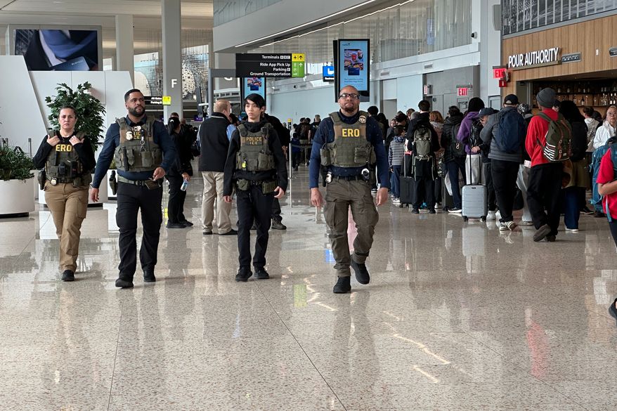 U.S. Immigration and Customs Enforcement (ICE) agents patrol LaGuardia Airport in New York as a long line of people waits to go through TSA screening on Wednesday, March 25, 2026. (AP Photo/Ted Shaffrey)