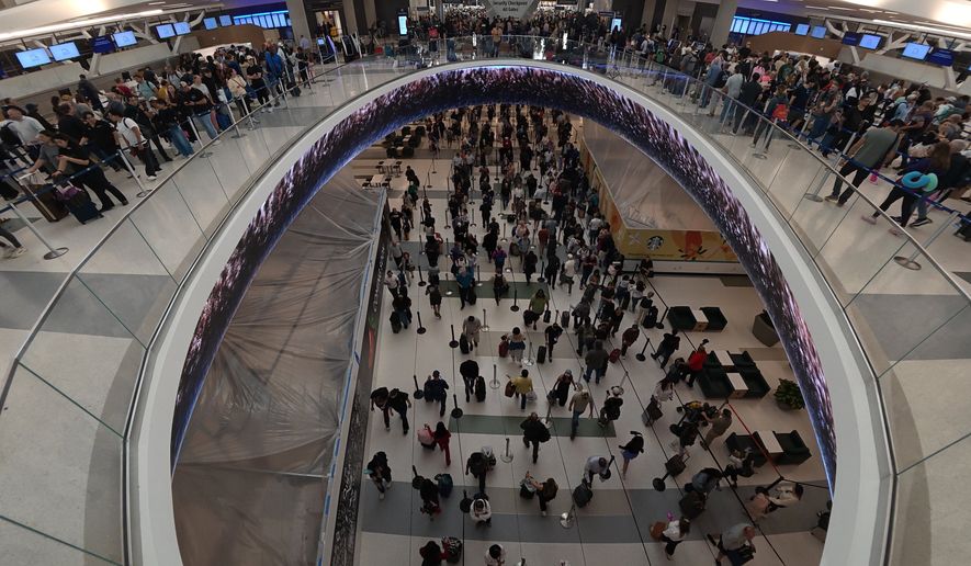 Travelers line up at a TSA checkpoint at George Bush Intercontinental Airport in Houston, Thursday, March 26, 2026. (AP Photo/Lekan Oyekanmi)