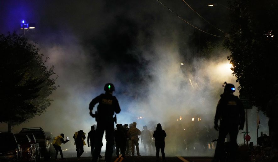 Law enforcement officers stand after deploying tear gas outside a U.S. Immigration and Customs Enforcement facility during a protest on Oct. 4, 2025, in Portland, Ore. (AP Photo/Jenny Kane, File)
