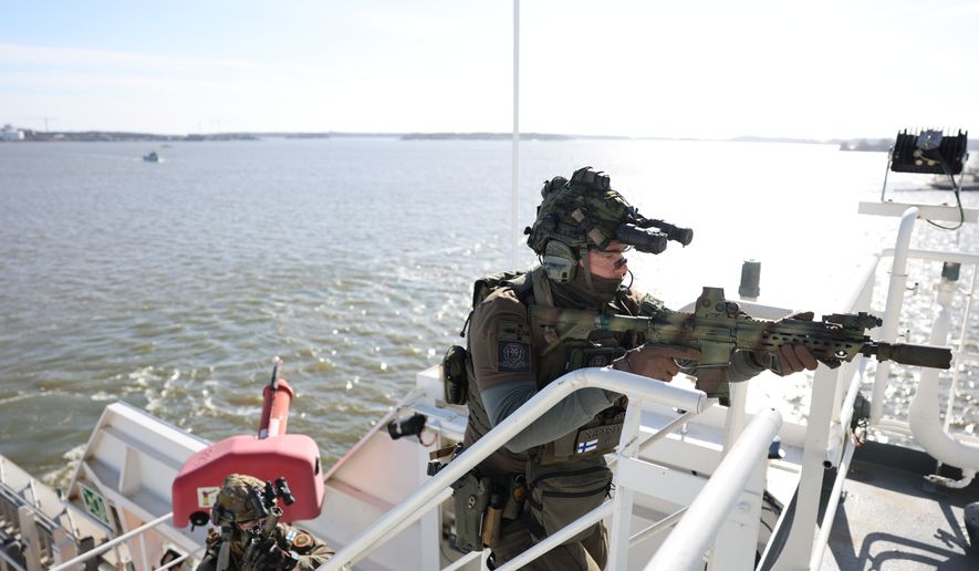 A member of the Finnish Border Guard takes part in an exercise, during the JEF leaders' visit on the Finnish Border Guard offshore patrol vessel Turva, prior to the Joint Expeditionary Force JEF Leaders' Summit in Helsinki, Finland, Thursday March 26, 2026. (Adrian Dennis, Pool Photo via AP)