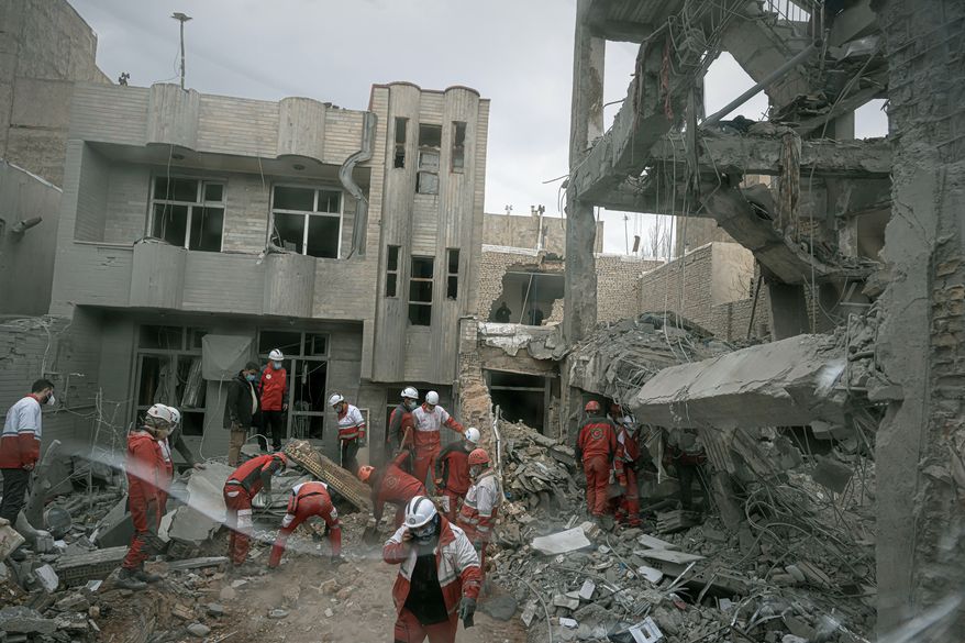 First responders inspect the remains of a residential building hit in an overnight strike during the U.S.-Israeli military campaign in Tabriz, Iran, March 24, 2026. (AP Photo/Matin Hashemi, File)