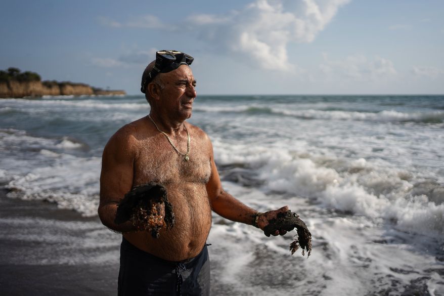 Fisherman Leopoldo Salgado holds clumps of oil residue collected along the shore days after an oil spill in the Gulf of Mexico that authorities said originated from an unidentified vessel and two natural oil seeps in Salinas, Mexico, Thursday, March 26, 2026. (AP Photo/Felix Marquez)