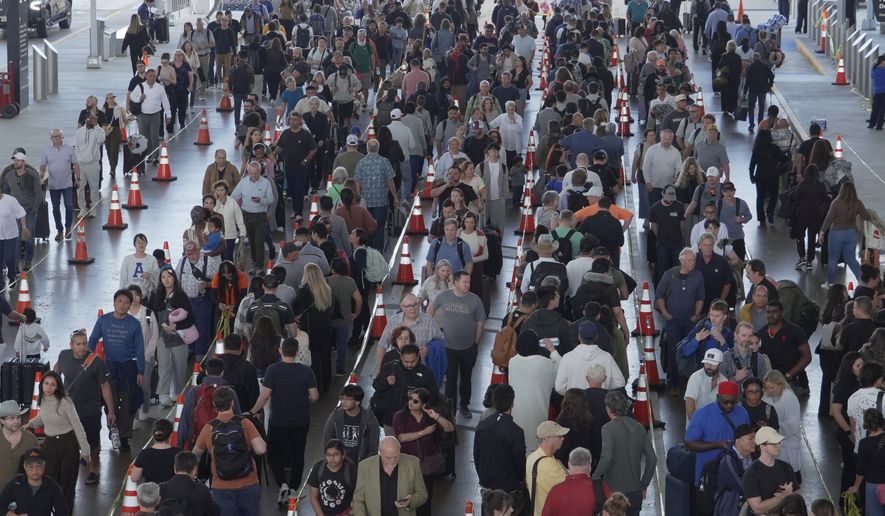 Travelers line up at a TSA checkpoint at George Bush Intercontinental Airport in Houston, Thursday, March 26, 2026. (AP Photo/Lekan Oyekanmi)