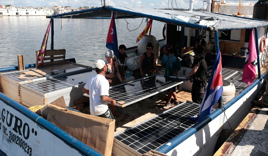 Activists from the vessel Maguro, that arrived from Mexico, unload solar panels and other humanitarian aid from the "Nuestra America," or Our America convoy, at the port in Havana Bay, Cuba, Tuesday, March 24, 2026. (Jorge Luis Banos/IPS via AP, Pool)