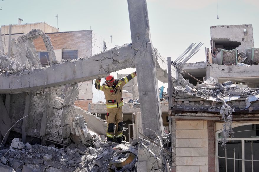A first responder inspects the damaged structure of a residential building hit in an earlier U.S.-Israeli strike in Tehran, Friday, March 27, 2026. (AP Photo/Vahid Salemi)