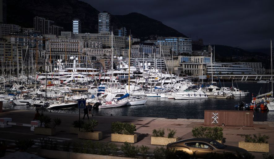 A luxury car drives along Monaco Harbor, Nov. 19, 2020. (AP Photo/Daniel Cole, File)