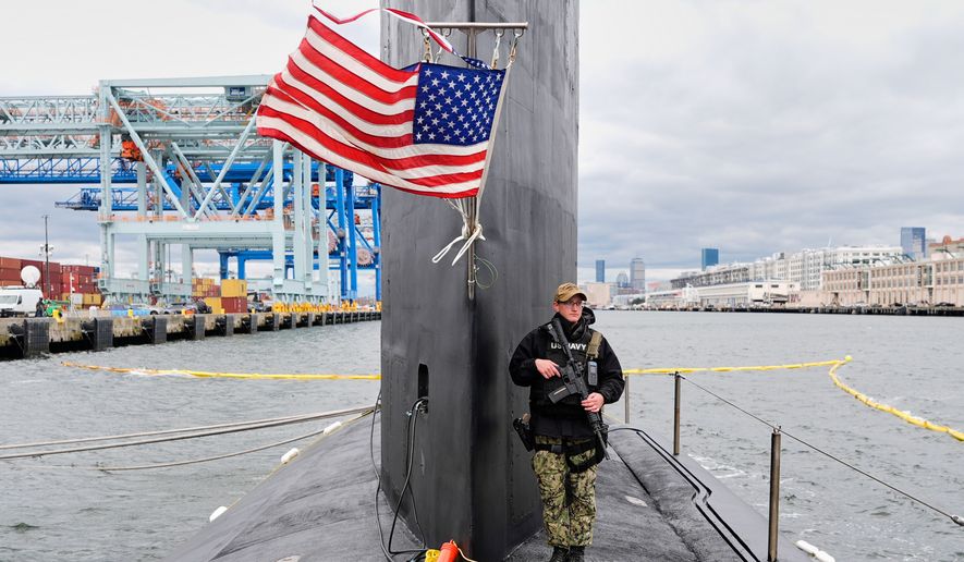 A sailor stands guard next to the sail of the USS Massachusetts, the Navy's newest nuclear-powered attack submarine, Friday, March 27, 2026, in Boston. (AP Photo/Robert F. Bukaty)