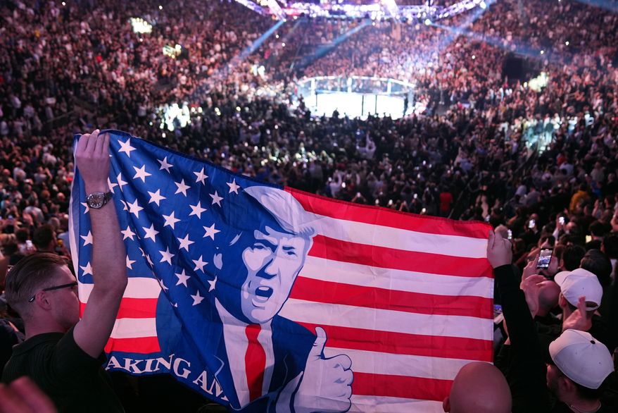 People hold a flag as President-elect Donald Trump arrives at UFC 309 at Madison Square Garden, Nov. 16, 2024, in New York. (AP Photo/Evan Vucci, File)