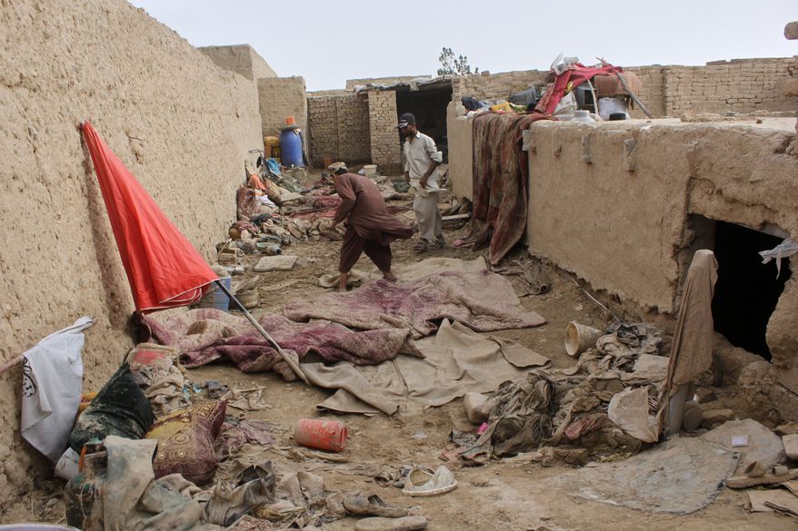 Locals inspect a damaged house following floods, landslides and thunderstorms in Kandahar province, Afghanistan, Sunday, March 29, 2026. (AP Photo/Sibghatullah)