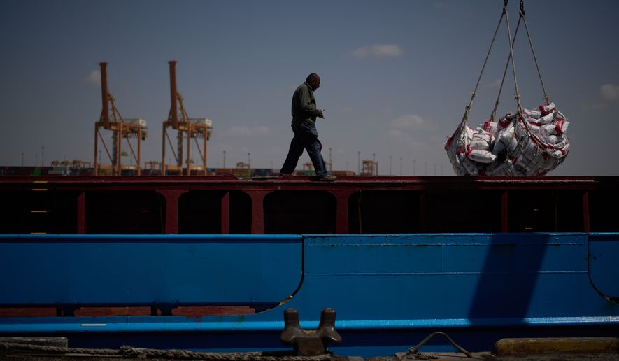 A worker walks on the deck of a feeder vessel as he works to offload cargo of rice into trucks at Umm Qasr Port, a deep-water port, in the city of Umm Qasr, Iraq, Friday, March 27, 2026. (AP Photo/Leo Correa)