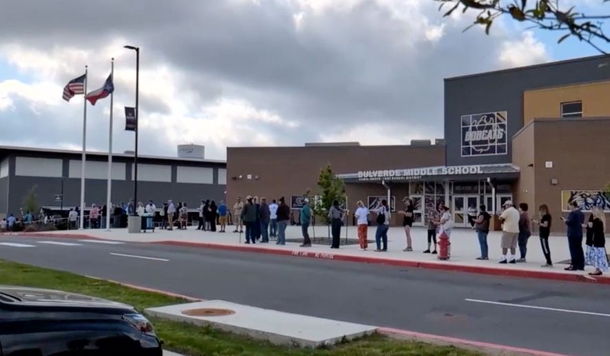 This image taken from video provided by KSAT shows parents waiting in line outside Bulverde Middle School to be reunited with their children after a teacher was shot by a student at Hill Country College Preparatory High School, Monday, March 30, 2026, in Bulverde, Texas. (KSAT via AP)