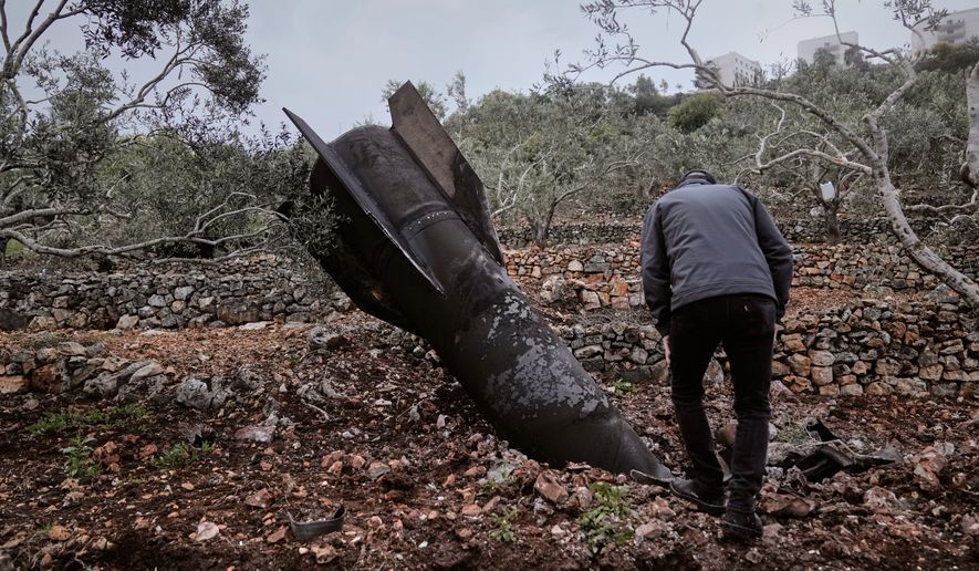 A man inspect the wreckage of an Iranian missile that landed near the West Bank village of Marda, Tuesday, March 31, 2026. (AP Photo/Majdi Mohammed)
