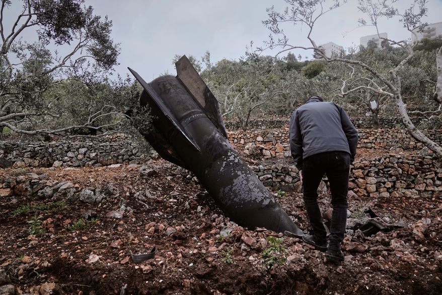 A man inspect the wreckage of an Iranian missile that landed near the West Bank village of Marda, Tuesday, March 31, 2026. (AP Photo/Majdi Mohammed)