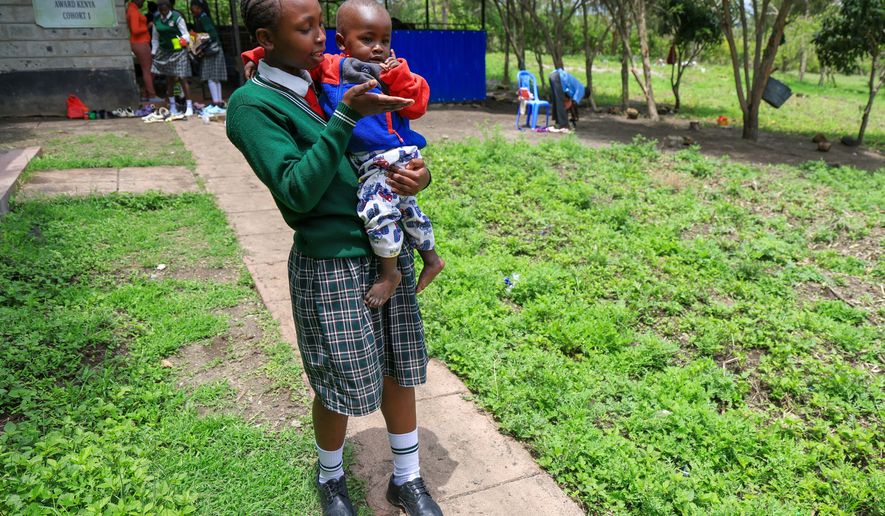 Valarie Wairimu, 19, interacts with her son, Kayden Darmain during breaktime at Greenland Girls School in Kiserian, Kajiado, Kenya, March 5, 2026. (AP Photo/Andrew Kasuku)