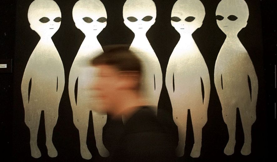 A patron passes a painting inside the International UFO Museum and Research Center in Roswell, N.M., on June 10, 1997. (AP Photo/Eric Draper, File)